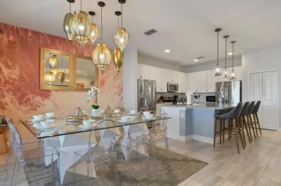 a dining room and kitchen with a glass table and chairs at Elegant Home with Pool & Spa, Close to Disney in Kissimmee