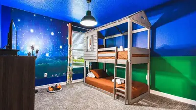 a bedroom with a bunk bed and a blue wall at Disney-Themed Oasis with Private Pool & Spa in Kissimmee