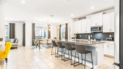 a kitchen and living room with a bar and chairs at Storey Lake Resort 6br Family Villa Pool by Disney in Kissimmee