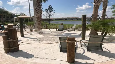 a beach with hammocks and chairs on the sand at Storey Lake 2BR Cozy Resort Home Close to Disney in Kissimmee