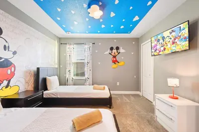 a bedroom with two beds and a ceiling with mickey mouse on it at Storey Lake Getaway Pool SPA Theater in Kissimmee
