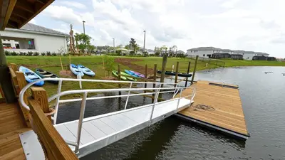 a boat is docked at a dock on the water at 4BR Tropical Storey Lake Townhome Private Pool in Kissimmee