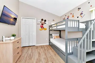 a bedroom with a bunk bed with mickey mouse on the wall at Lakeview Luxury Oasis in Kissimmee