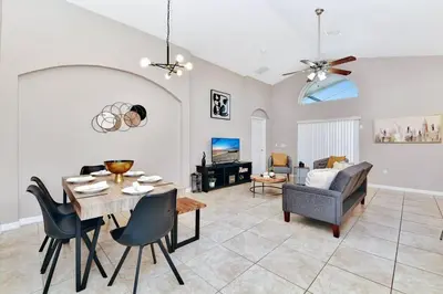 a living room with a table and chairs and a couch at Lakeview Luxury Oasis in Kissimmee