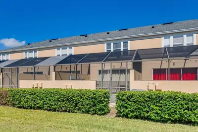 a building with red windows and bushes in front of it at T7676F Windsor Hills Resort 3Bed POOL Pet Friendly in Orlando
