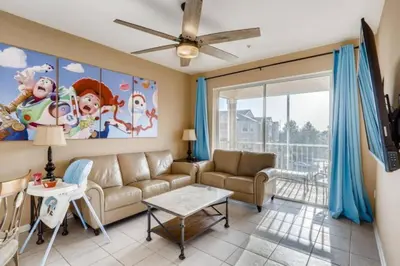 a living room with a couch and a large window at C7671-402 Windsor Hills Resort 2Bedrm Themed Condo in Orlando