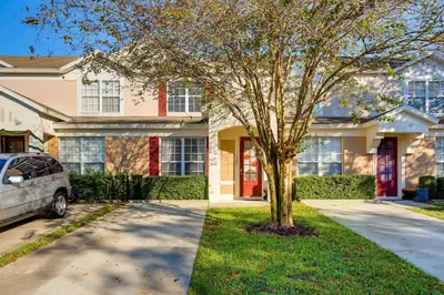 a house with a tree in front of a driveway at T2367 Windsor Palm Resort Pool 3 miles to Disney in Kissimmee