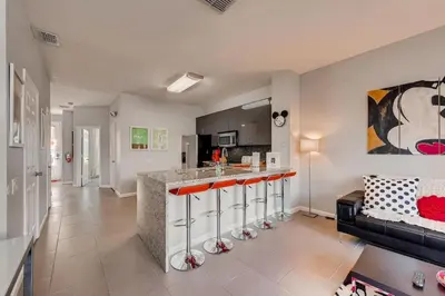 a kitchen and living room with a bar and a couch at T2367 Windsor Palm Resort Pool 3 miles to Disney in Kissimmee
