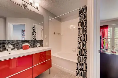 a bathroom with a tub and a sink and a mirror at T2367 Windsor Palm Resort Pool 3 miles to Disney in Kissimmee