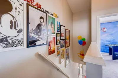a hallway with a bunch of pictures on a wall at T2367 Windsor Palm Resort Pool 3 miles to Disney in Kissimmee