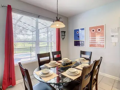 a dining room with a table and chairs and a window at H2713M Windsor Hills Resort 4Bedrm POOL SPA Disney in Orlando