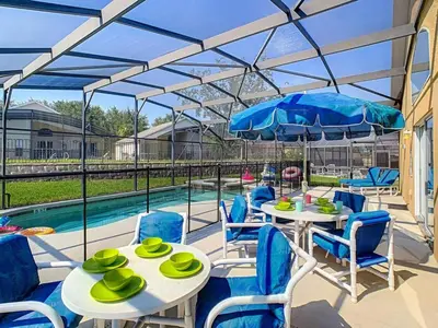 a patio with tables and chairs and a pool at H8536 Single Level Pool Spa Home 5 Bed Near Disney in Kissimmee