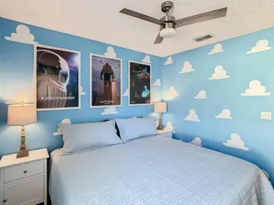 a blue bedroom with a bed and clouds on the wall at H8536 Single Level Pool Spa Home 5 Bed Near Disney in Kissimmee