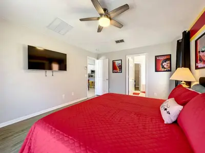 a bedroom with a red bed and a ceiling fan at H2631E Resort Single Level POOL SPA Home Disney in Kissimmee