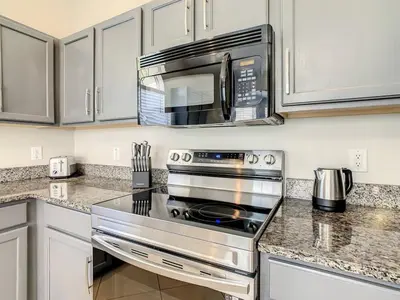 a kitchen with a stainless steel stove and a microwave at H2553O Single Level 5 Bedrm Pool 3Miles Disney in Kissimmee