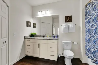 a bathroom with a toilet and a sink and a mirror at 3206 Gold in Kissimmee