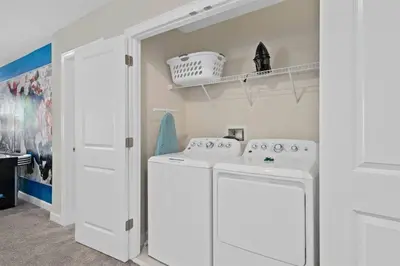 a white laundry room with a washer and dryer at Magic Marvel Getaway in Kissimmee