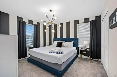 a bedroom with a blue bed and a chandelier at Magic Marvel Getaway in Kissimmee