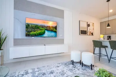 a living room with a tv hanging on a wall at Charming 4Bd w Private Pool @ Storey Lake Resort 2653 in Kissimmee