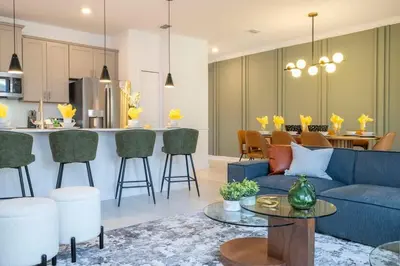 a living room with a blue couch and a kitchen at Charming 4Bd w Private Pool @ Storey Lake Resort 2653 in Kissimmee