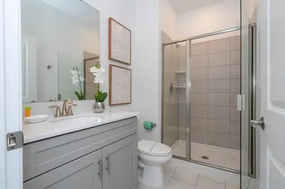 a bathroom with a toilet sink and a shower at Charming 4Bd w Private Pool @ Storey Lake Resort 2653 in Kissimmee