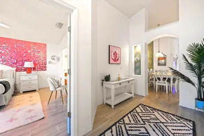 a bedroom with a desk and a dining room at Disney World Getaway: 4 Br - Sunroof - BBQ Bliss in Orlando
