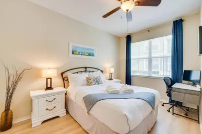 a bedroom with a bed and a desk with a computer at Haven Beautiful 3 BR TH in Gated Resort Community in Kissimmee