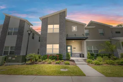 a large house with a lawn in front of it at New Home 5 Bedrooms and 4 Bathrooms At Storey Lake in Kissimmee