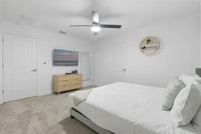 a white bedroom with a bed and a ceiling fan at New Home 5 Bedrooms and 4 Bathrooms At Storey Lake in Kissimmee