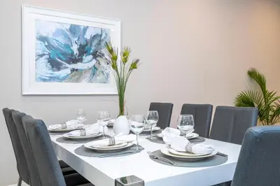 a dining room with a white table and chairs at Awesome 4 Suites Villa 5 Min to Disney in Orlando