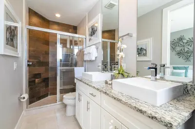 a bathroom with a white sink and a shower at Awesome 4 Suites Villa 5 Min to Disney in Orlando