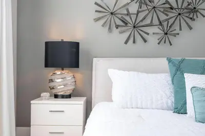 a bedroom with a white bed with a lamp on a nightstand at Awesome 4 Suites Villa 5 Min to Disney in Orlando