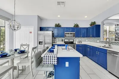 a kitchen with blue cabinets and a table and chairs at 8462 Secret Key Cove in Kissimmee