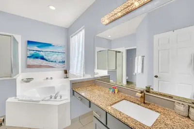 a bathroom with a sink and a large mirror at 8462 Secret Key Cove in Kissimmee