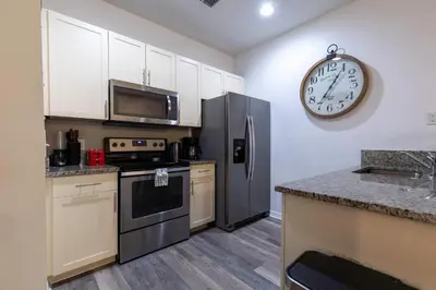 a kitchen with a refrigerator and a clock on the wall at Fabulous townhome near the Parks in Kissimmee