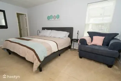 a bedroom with a bed and a chair at Beautiful vacation home near Disney in Kissimmee