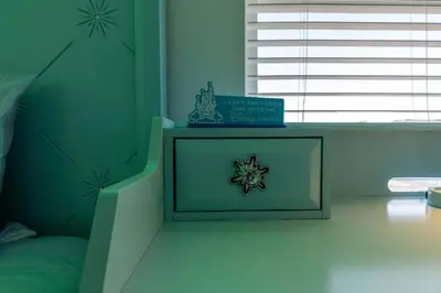 a bedroom with a bed and a table with a clock on it at Amazing house near the parks in Kissimmee