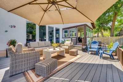a patio with furniture and an umbrella on a deck at 1-Acre Backyard and Gym Spacious Apopka Escape! in Orlando