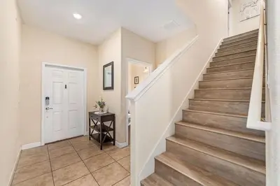 a staircase in a home with white walls and wooden floors at 9 min to Disney w Pool- 4BD 3BA - FREE Waterpark in Kissimmee