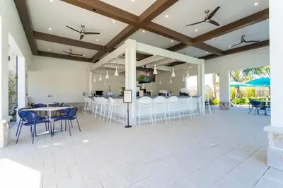 a patio with tables and chairs and a bar at 9 min to Disney w Pool- 4BD 3BA - FREE Waterpark in Kissimmee