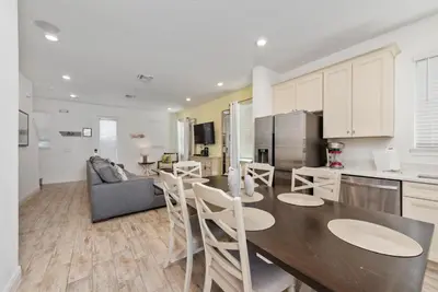 a kitchen and living room with a table and chairs at Private Pool! Big and Stylish House! in Orlando