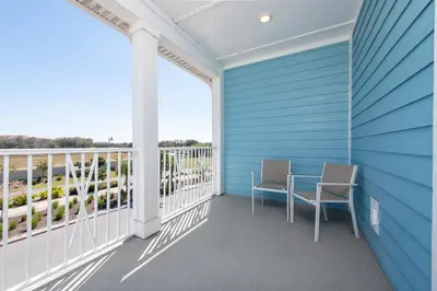 a balcony with two chairs and a table on a blue wall at Private Pool! Big and Stylish House! in Orlando