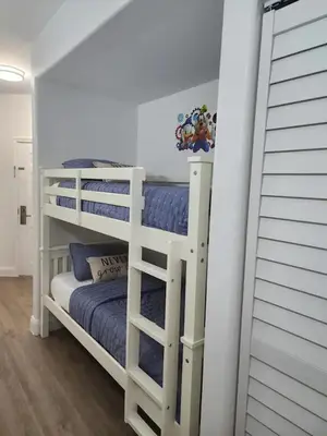 two white bunk beds in a white room at Orlando 3rd Floor - Blue Heron in Orlando