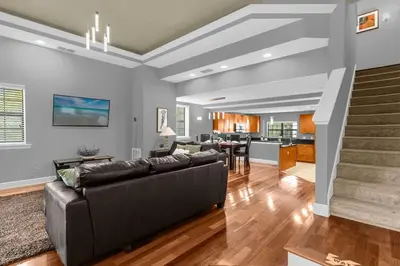 a living room with a couch and a kitchen at Cozy & Elegant 4BR Enchanted Townhouse - 1 Mile to Disney with Resort Pool, Gym, & Jacuzzi in Orlando