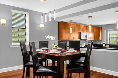 a dining room with a table and chairs at Cozy & Elegant 4BR Enchanted Townhouse - 1 Mile to Disney with Resort Pool, Gym, & Jacuzzi in Orlando