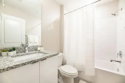 a white bathroom with a toilet and a sink at 8005 Stunning Villa Disney Park Proximity in Orlando