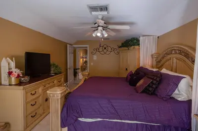 a bedroom with a purple bed with a ceiling fan at Paradise in a country setting 1100 sq ft apartment in Lake Mary