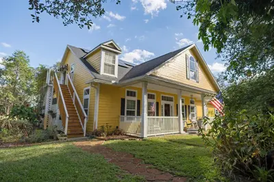 a yellow house with an american flag at Paradise in a country setting 1100 sq ft apartment in Lake Mary