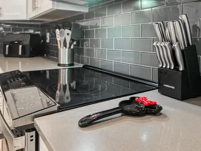 a kitchen counter with a stove top with a spatula at Happily Ever Home, Your Family Dream Beyond Disney in Kissimmee