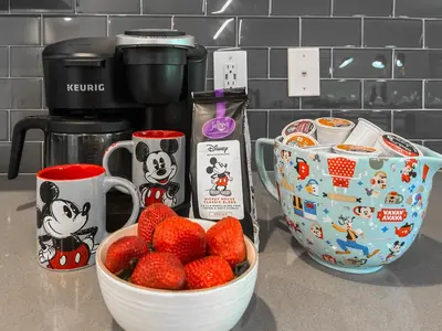 a bowl of strawberries on a counter next to a coffee maker at Happily Ever Home, Your Family Dream Beyond Disney in Kissimmee